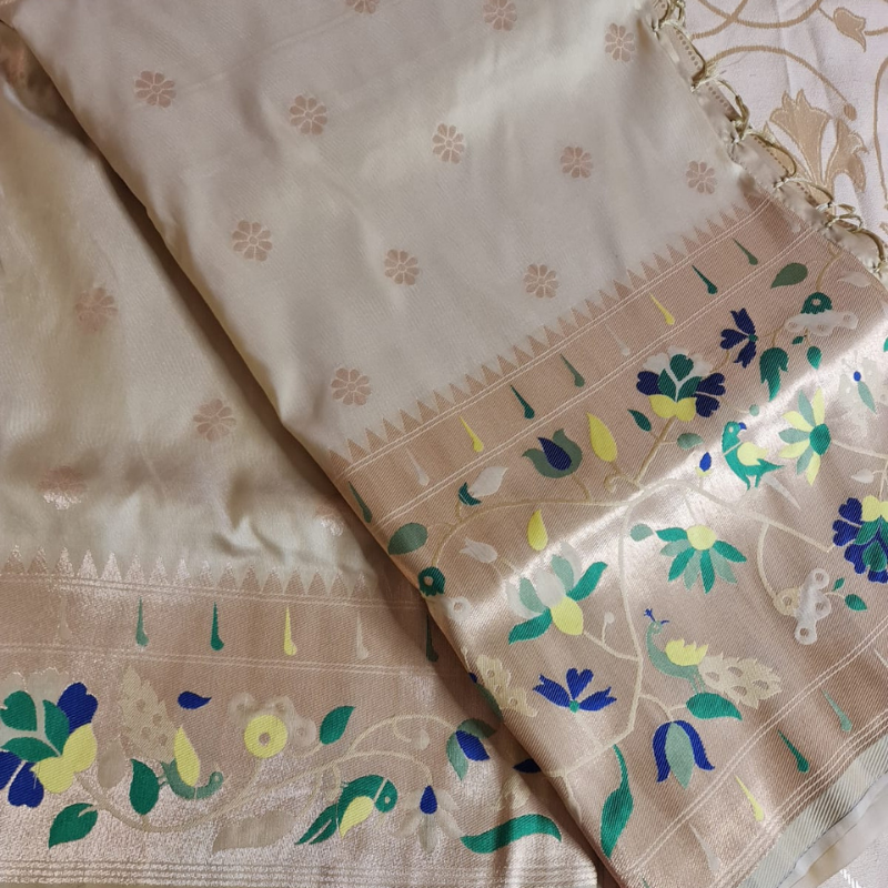 Champagne color Paithani saree with traditional peacock & lotus motifs in gold zari border with tassels