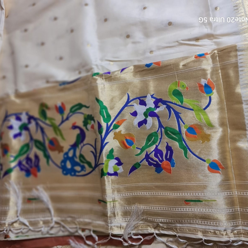 Cream Paithani saree with traditional peacock & lotus motifs in gold zari border with tassels