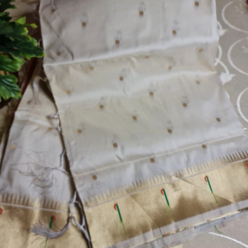 Cream Paithani saree with traditional peacock & lotus motifs in gold zari border with tassels