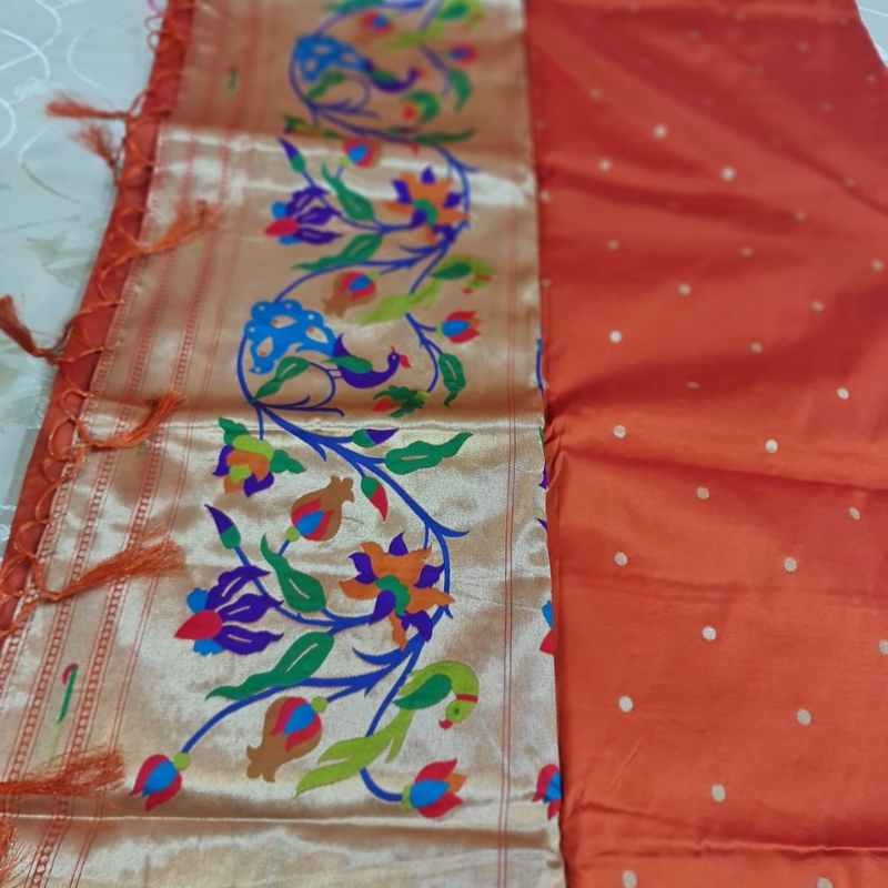 Orange Paithani saree with traditional peacock & lotus motifs in gold zari border with tassels