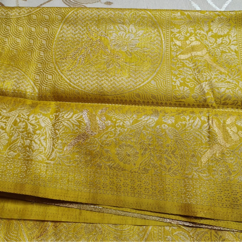 Yellow Benarasi saree with intricate gold zari detailing with tassels