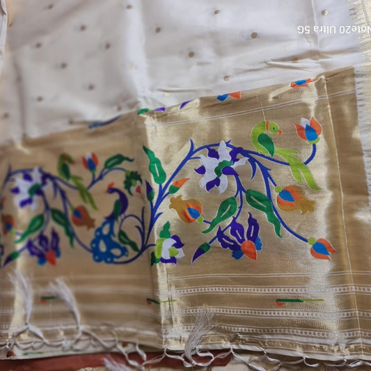 Cream Paithani saree with traditional peacock & lotus motifs in gold zari border with tassels